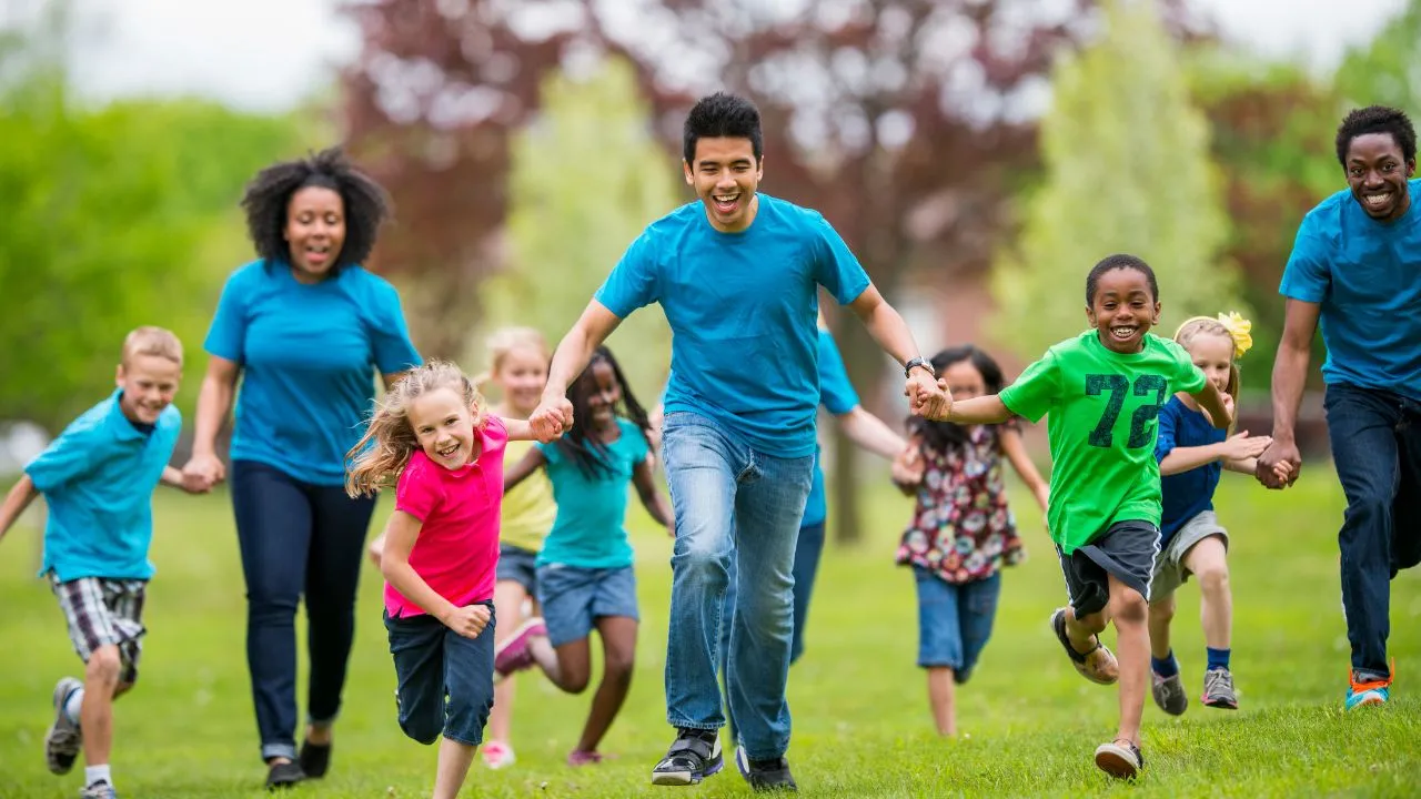 counselors running with kids at summer camp